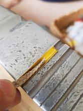 Cord placed in curved aglet blank